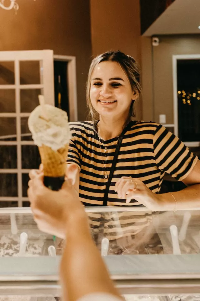 Woman giving an icecream to a customer